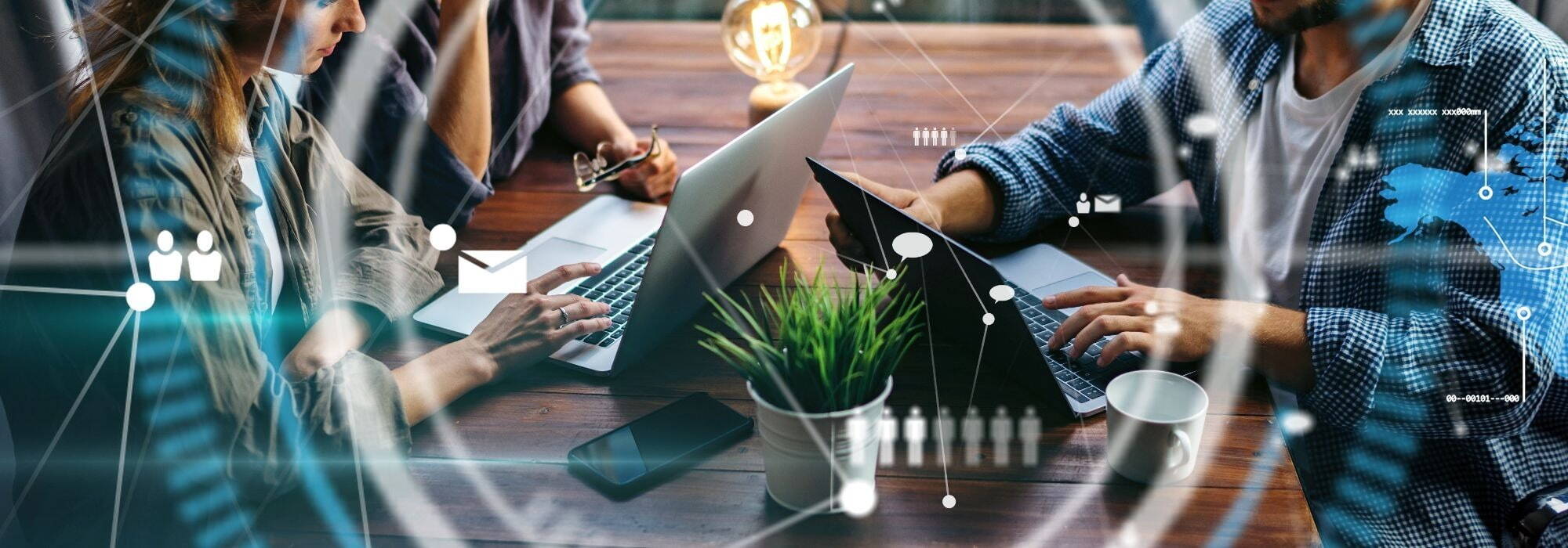 People working around a table with two laptops